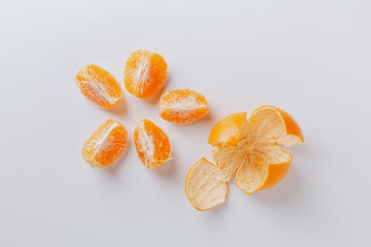 Top view of peeled and segmented mandarin on a white background, highlighting freshness and citrus appeal.